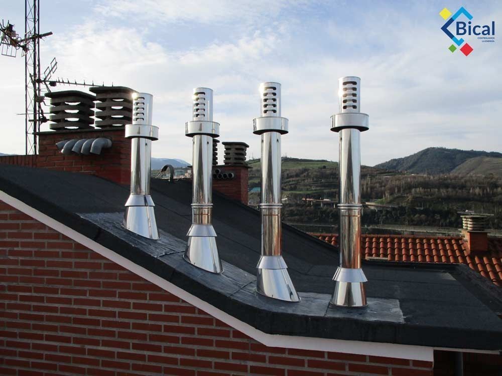 Un edificio de ladrillo con algunas chimeneas en la parte superior.