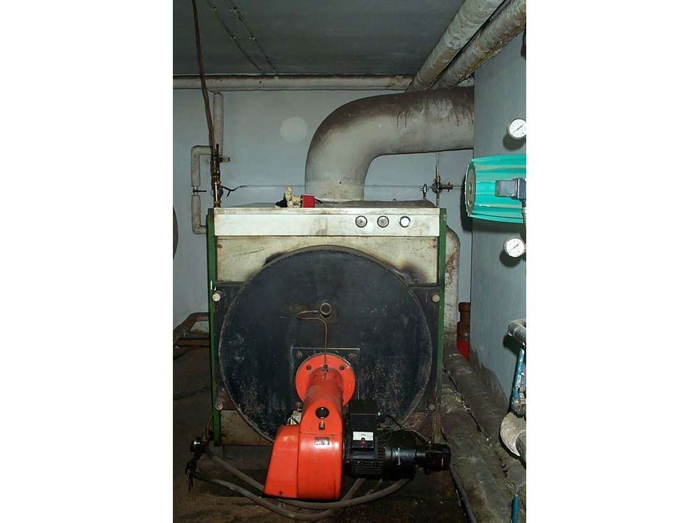 Hay una caldera grande en una habitación con una tubería que sale de ella.