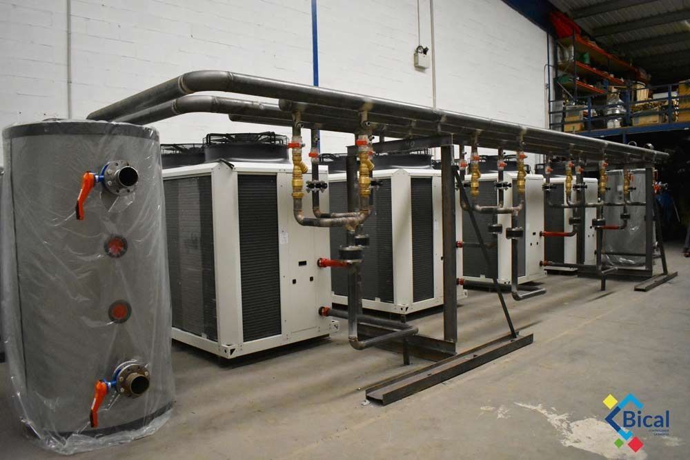 Una fila de calderas están alineadas en un almacén.