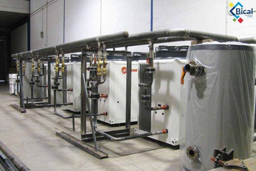 Una fila de calentadores de agua están alineados en una habitación.