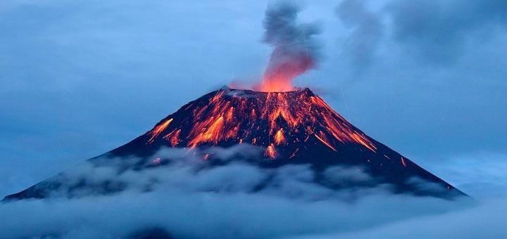 Un volcán está en erupción y sale lava de él.