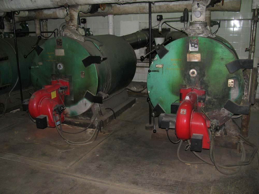 Hay dos calderas una al lado de la otra en una habitación.