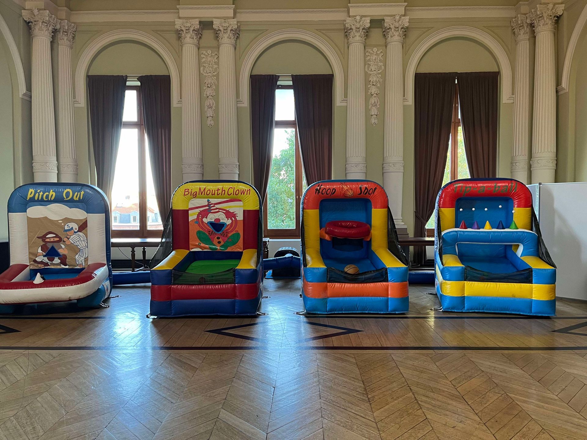 Quatre jeux gonflables de style arcade alignés à l'intérieur, dont des jeux de basket-ball et de cible.