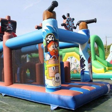 Un château gonflable sur le thème des pirates avec divers obstacles, dans un décor extérieur.