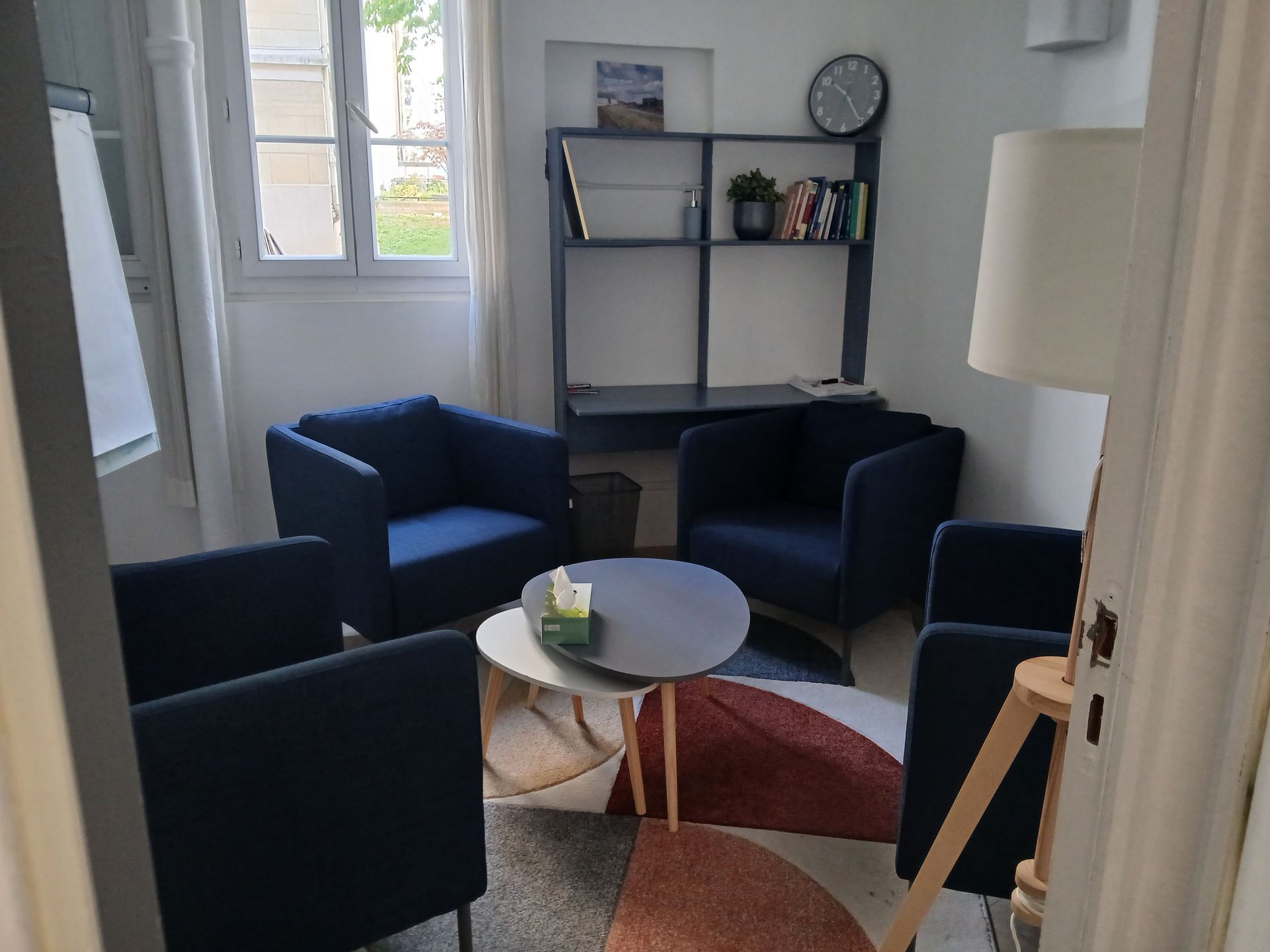 Fauteuils bleu marine autour de tables basses gigognes