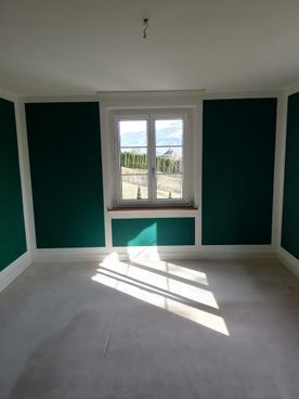 Flur mit eingelassener LED-Lichtleiste an der Decke. Licht erhellt Wände und Boden.