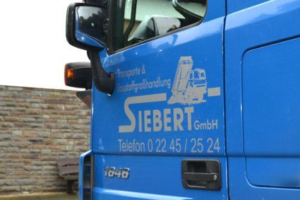 Ein blauer LKW mit dem Wort Siebert auf der Seite