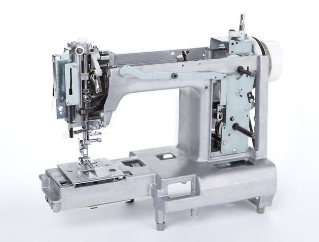 El interior de una máquina de coser se muestra sobre una superficie blanca.