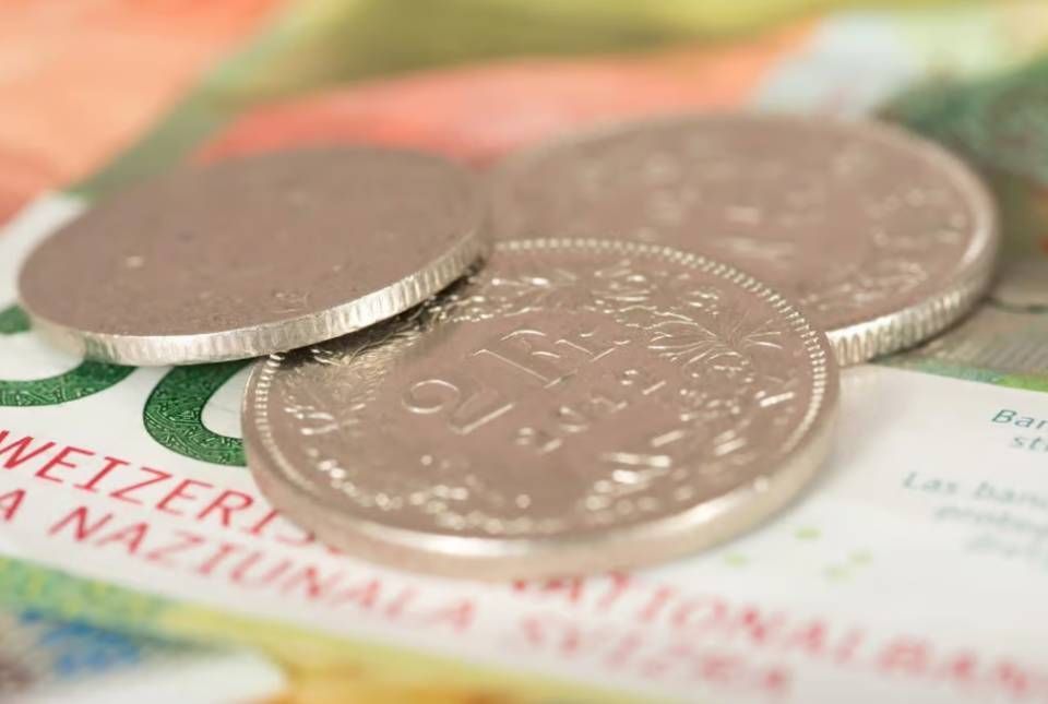Mehrere Silbermünzen auf einer Banknote vor verschwommenem Hintergrund
