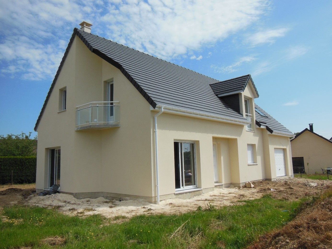 Maison aux murs jaune avec un petit balcon