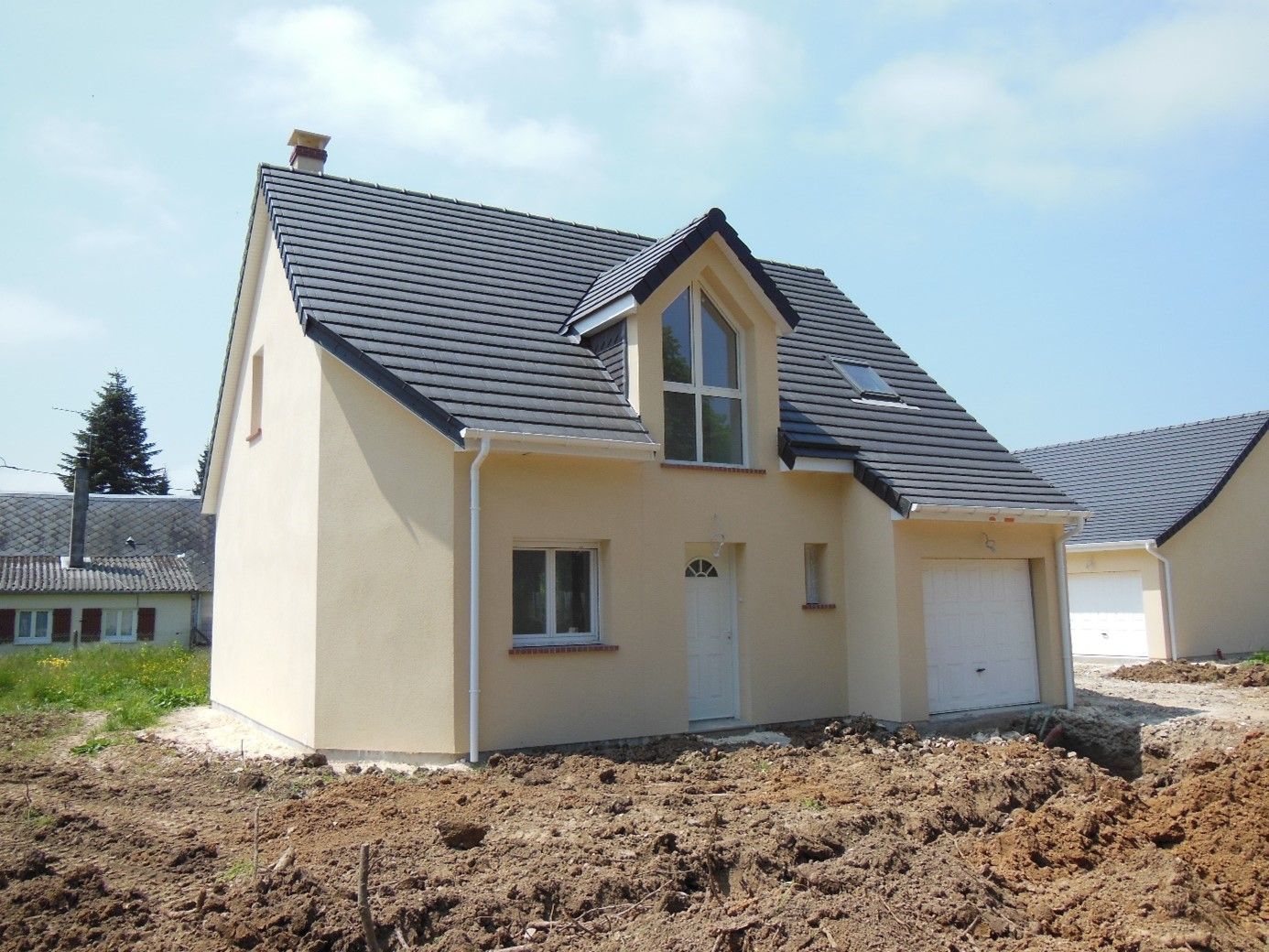 Maison aux murs jaune pâle et aux tuiles noires