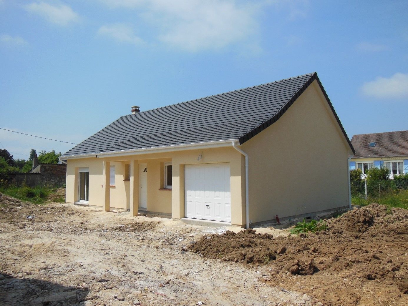 Maison avec garage et préau devant la porte d'entrée