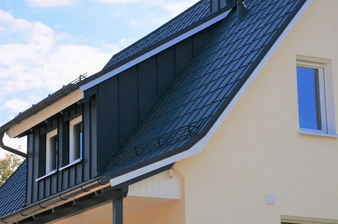 Modernes weißes Haus mit dunkel gedecktem Dach