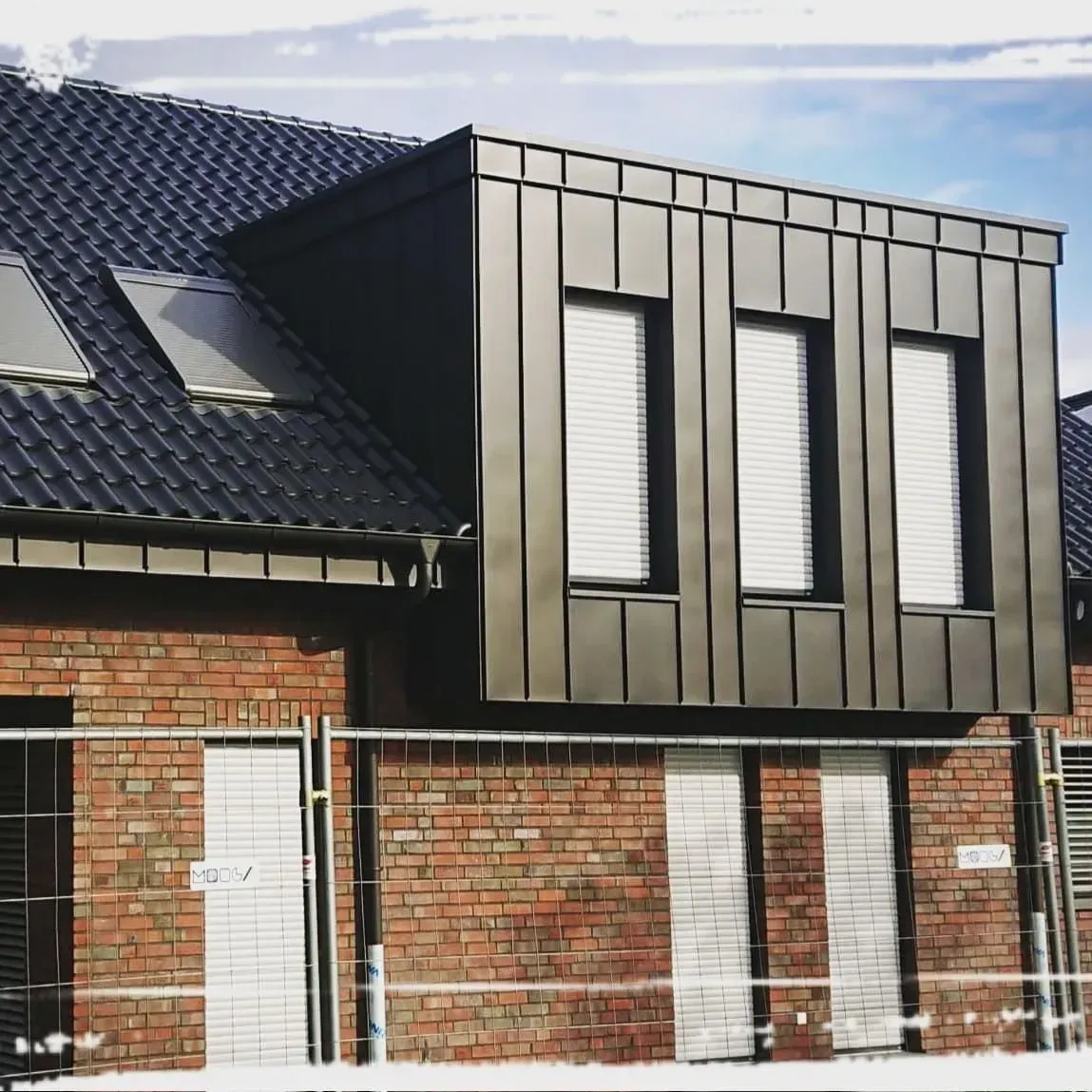 Haus mit dunkel gedecktem Dach und Dachfenstern