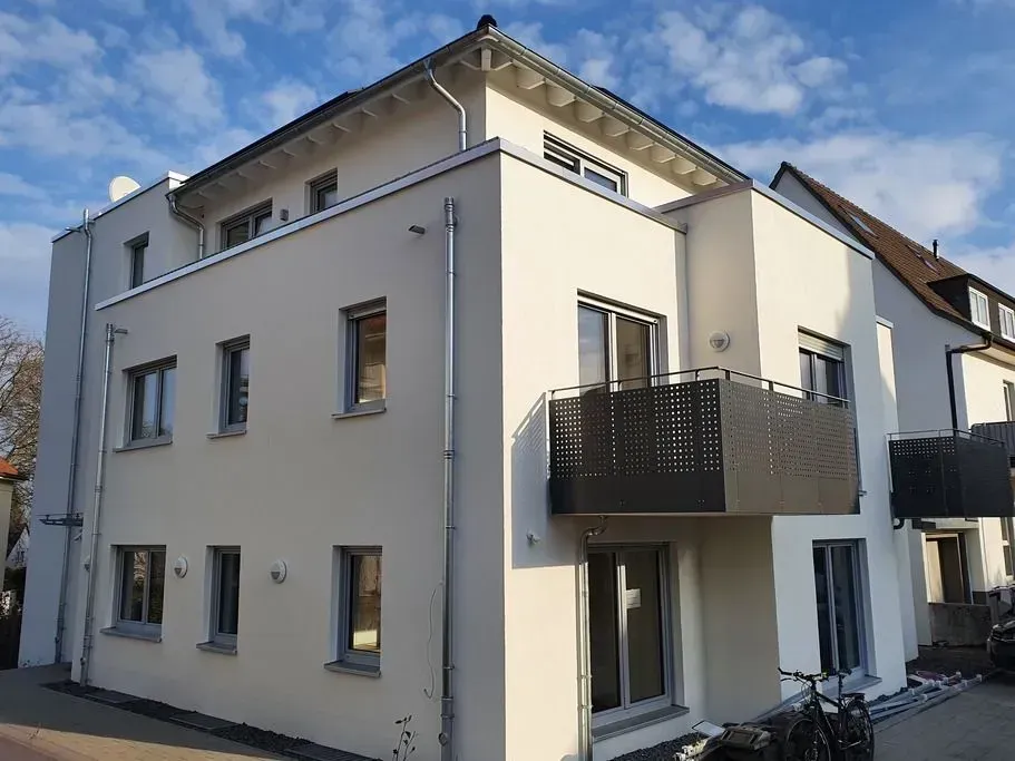 Weißes Gebäude mit schwarzem Balkon