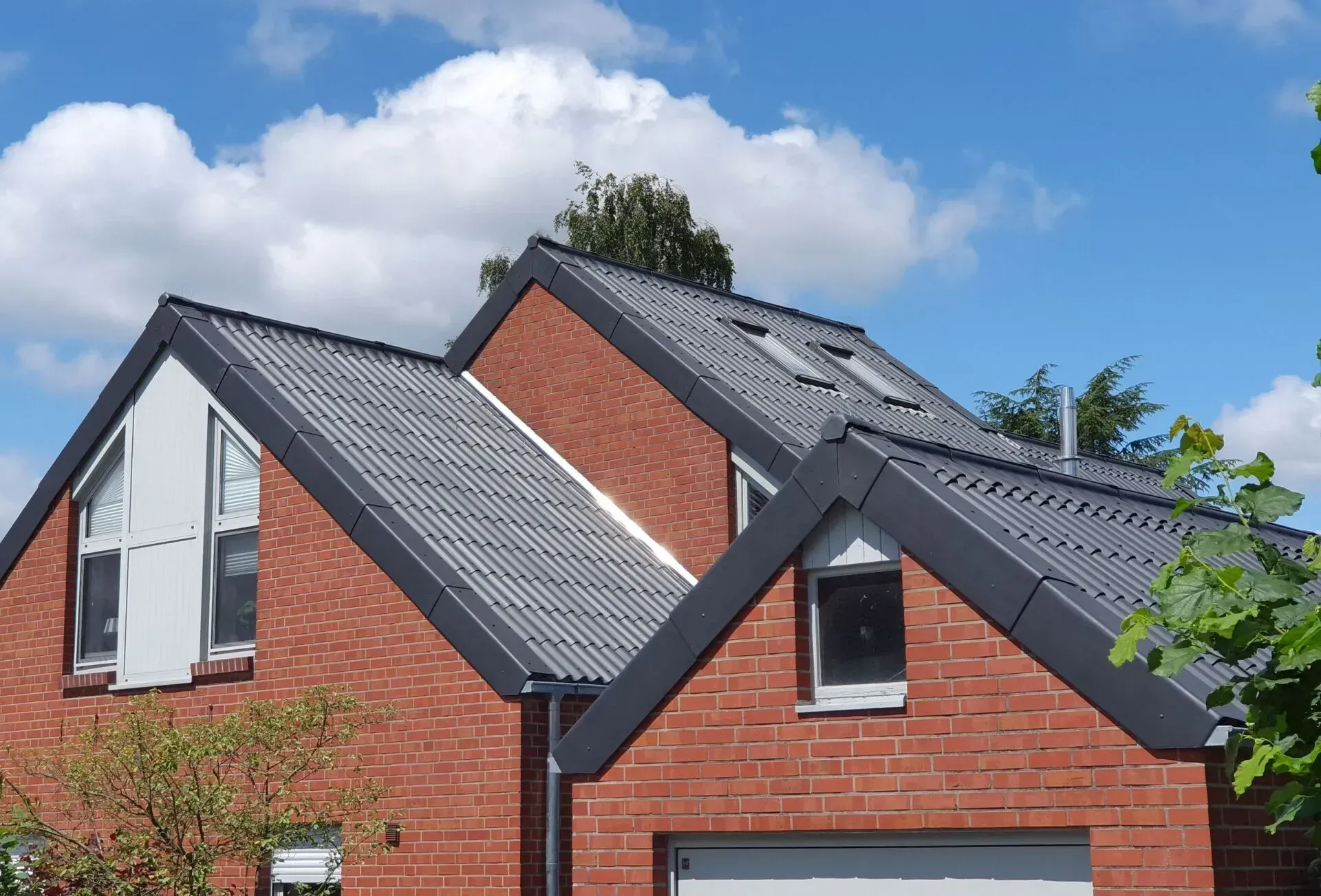 Wohnsiedlung: Neue Häuser mit dunkel gedeckten Dächern