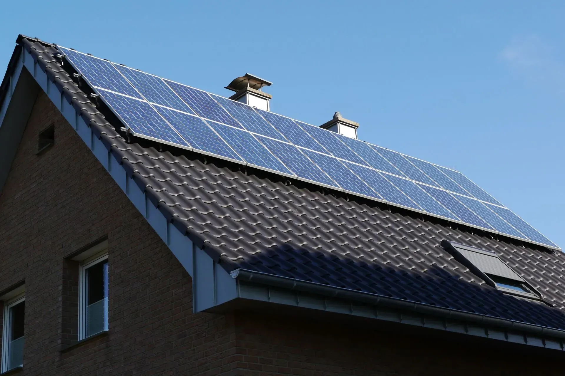 Dunkel gedecktes Dach mit Sonnen-Kollektoren einer Photovoltaik Anlage