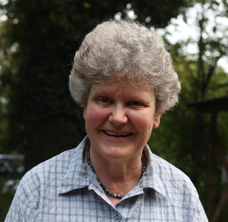 Eine ältere Dame lächelt in die Kamera