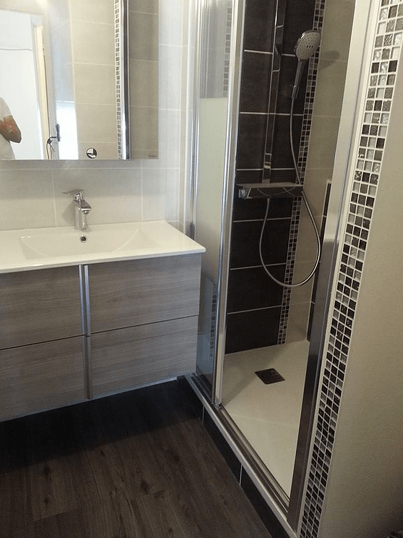 Nouveau meuble vasque à côté d'une cabine de douche rénovée