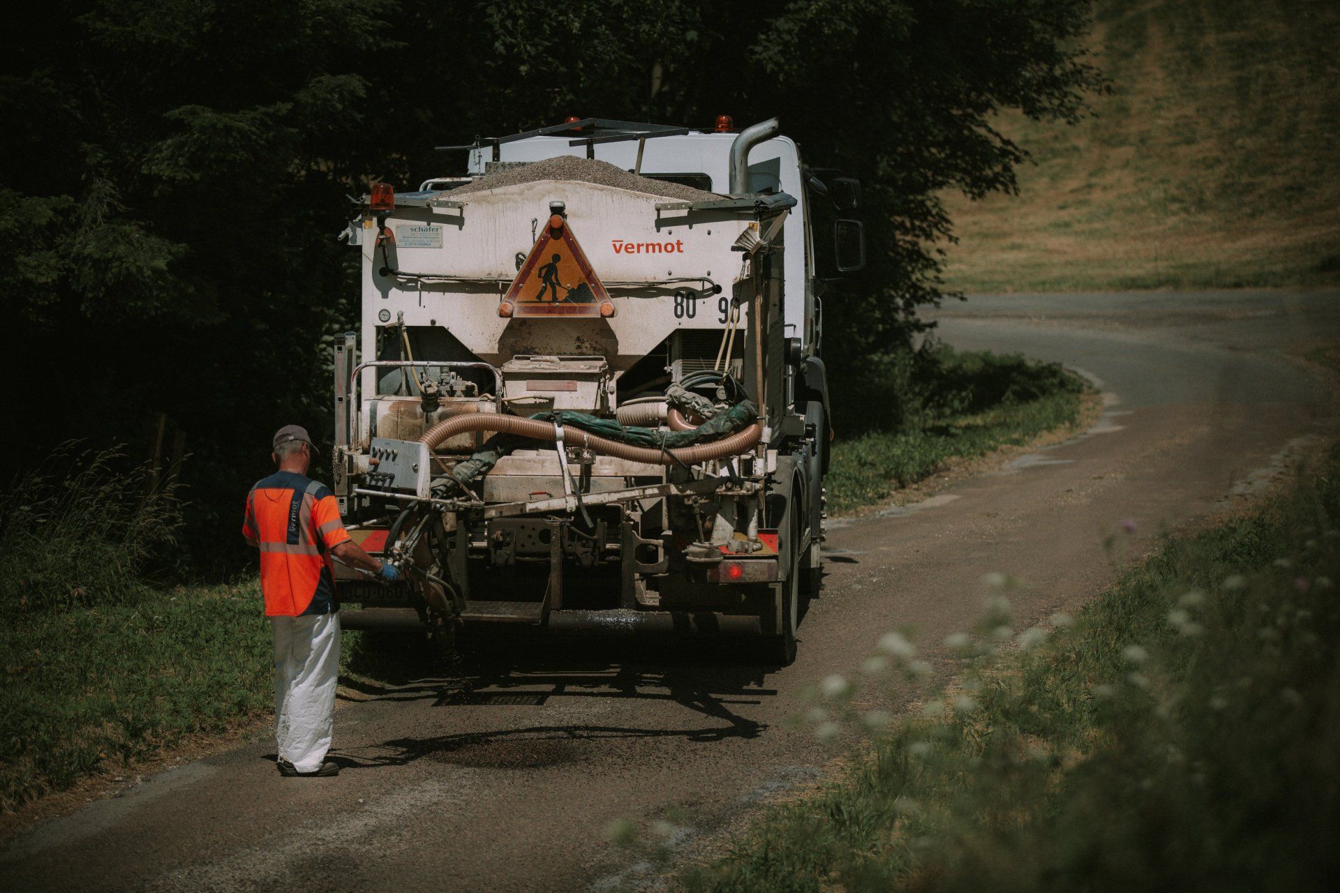 Camion Vermot déposant de l'enrobé sur une route