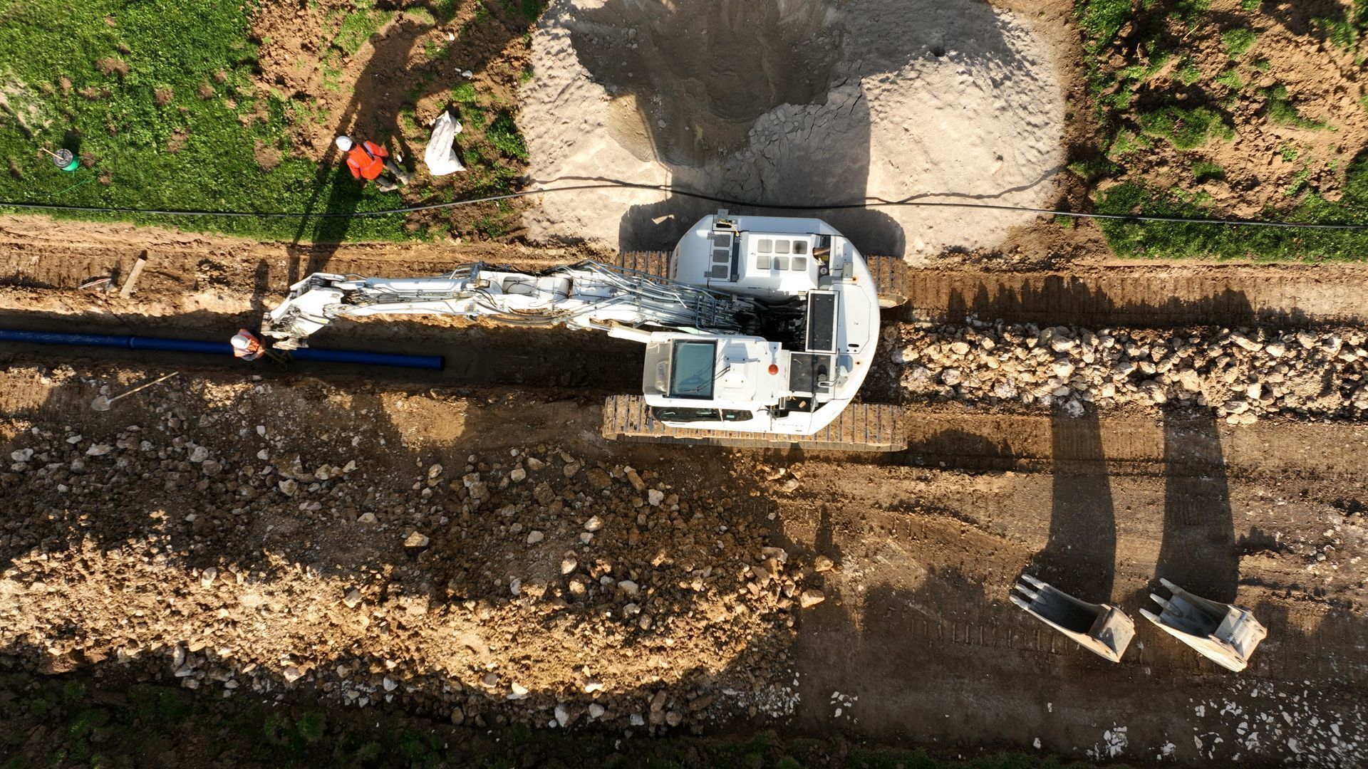 Tranchée de voirie avec banches de soutien de chaque côté pour passage de tuyau d'eau
