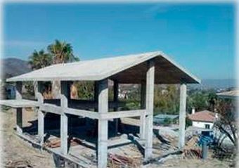 Se está construyendo una estructura de hormigón con techo en la cima de una colina.