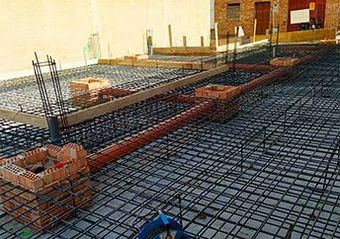 Un sitio de construcción con muchos tubos y ladrillos en el suelo.