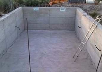 Una escalera está en el medio de una piscina de hormigón.