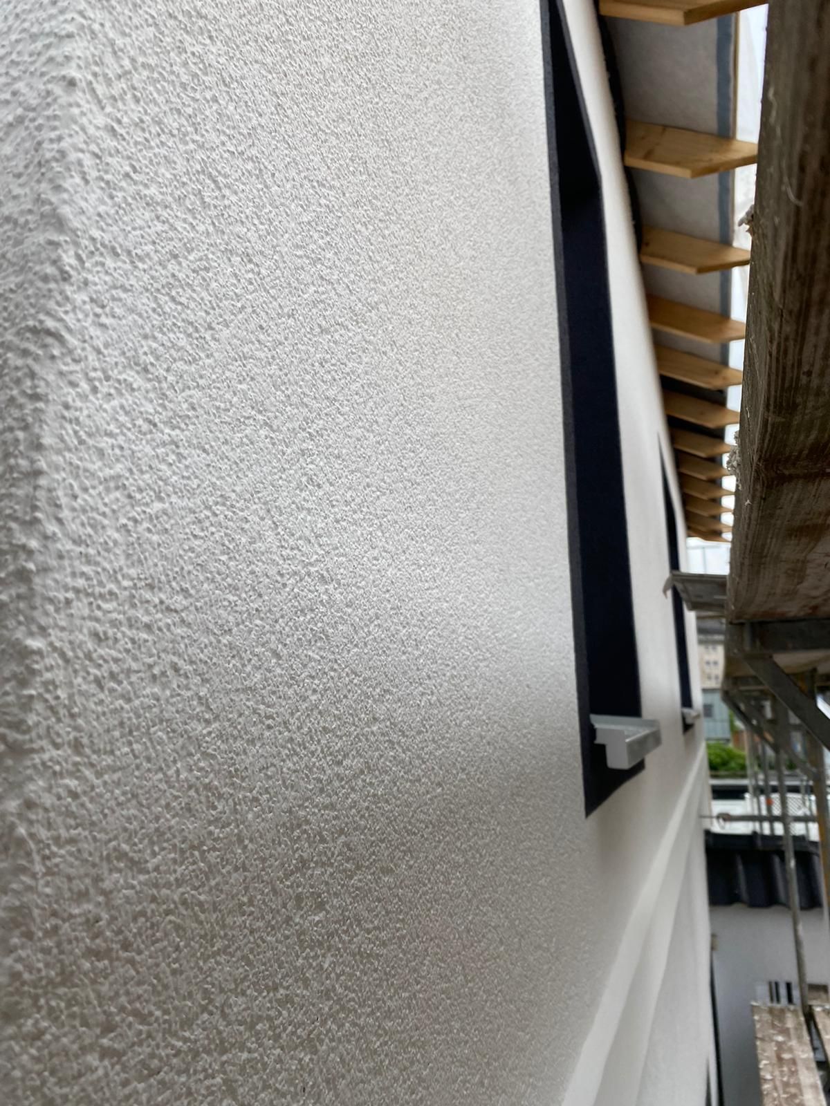 Eine Nahaufnahme eines weißen Gebäudes mit schwarzen Fenstern