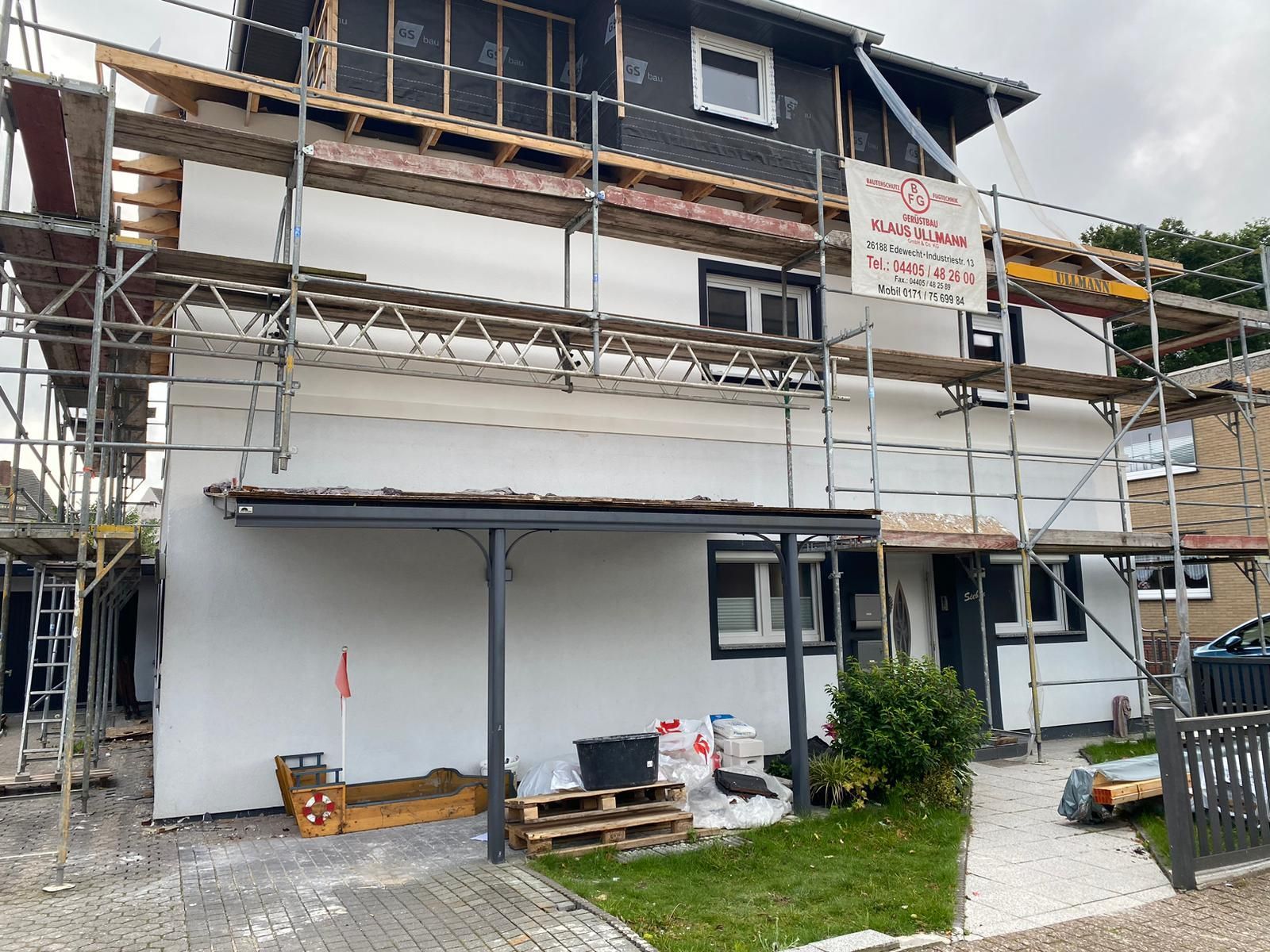 Es wird ein Haus gebaut, das von einem Gerüst umgeben ist.