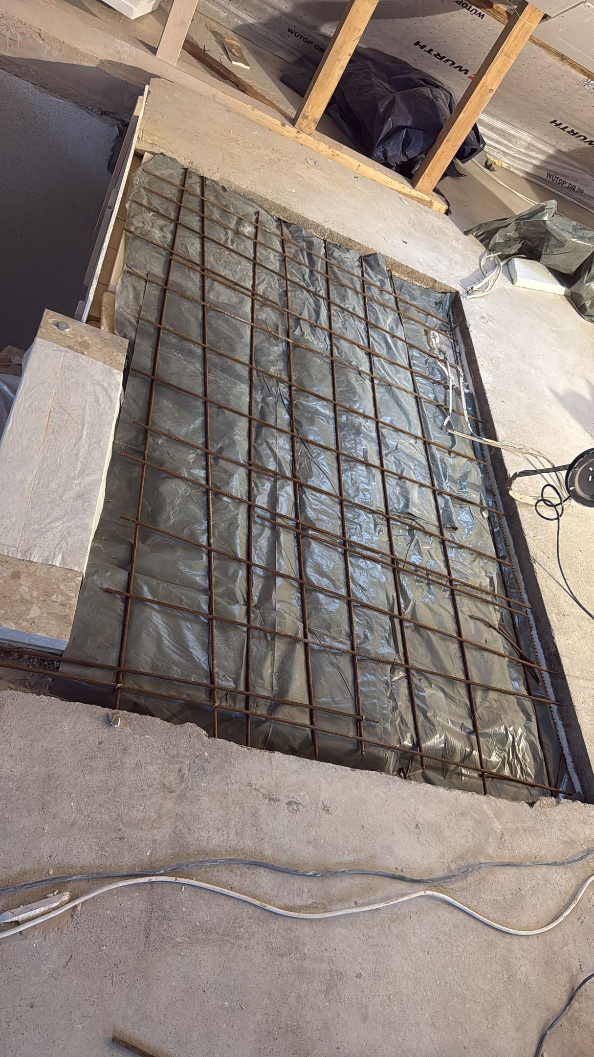 Eine Nahaufnahme eines Betonbodens mit einem Metallgitter darauf.