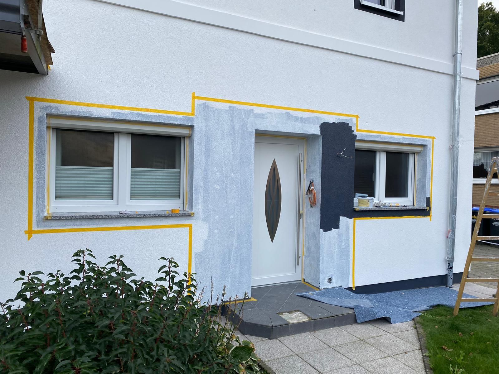 Ein weißes Haus mit Tür und Fenstern wird gestrichen