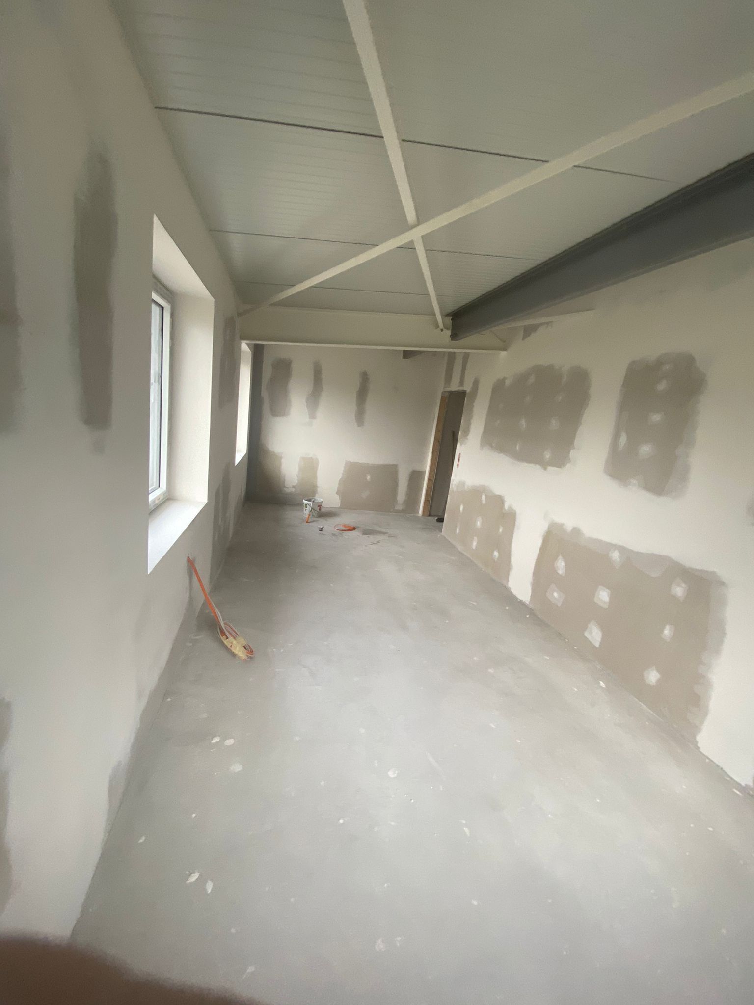 Ein großer leerer Raum mit einer Decke und einem Fenster.