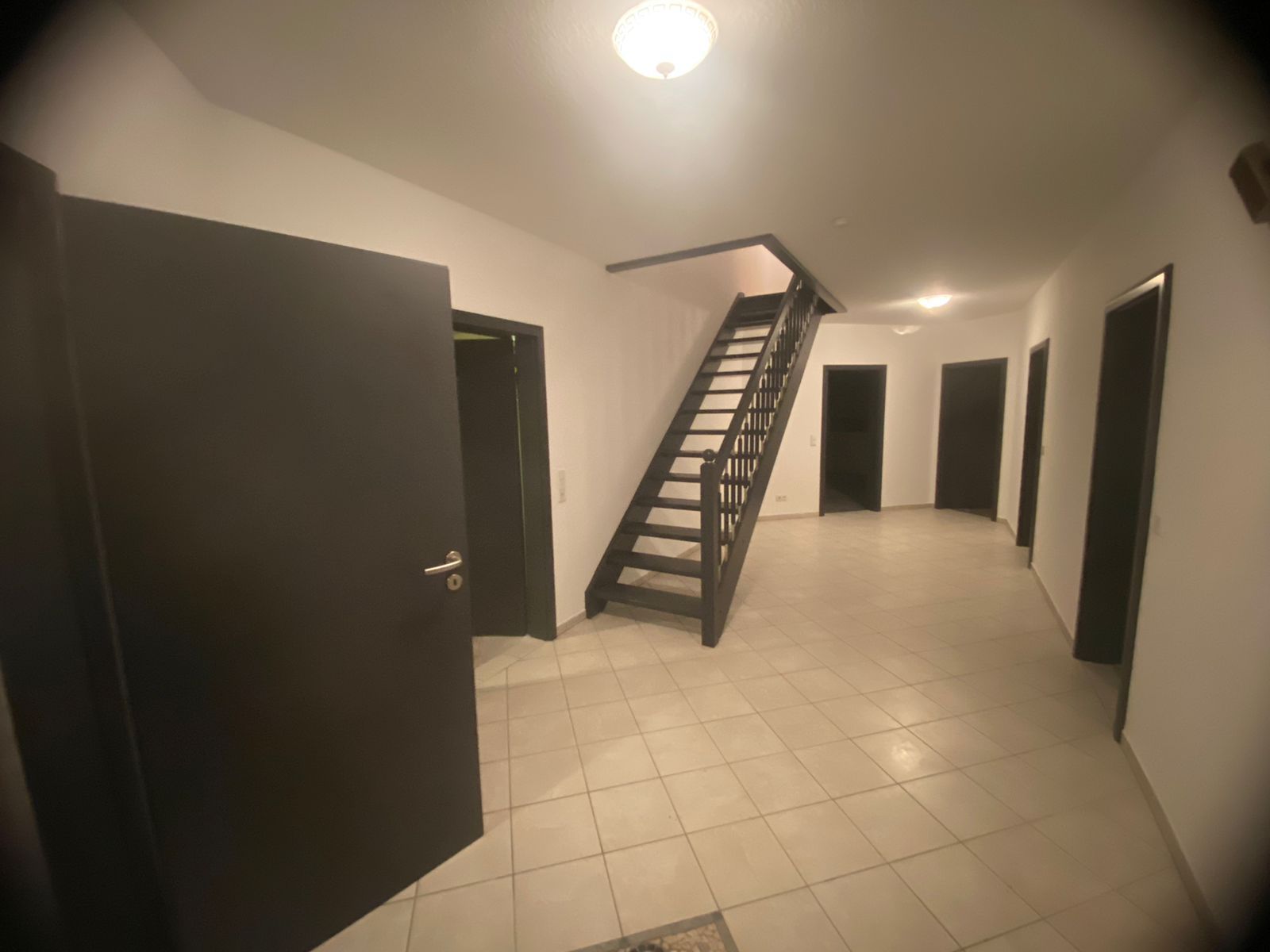 Ein Flur mit einer Treppe, die in den zweiten Stock führt