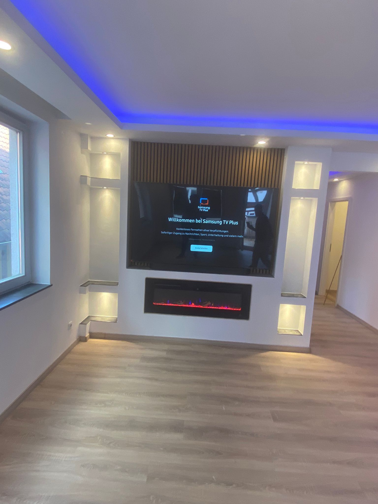 Ein Wohnzimmer mit Kamin und Flachbildfernseher.