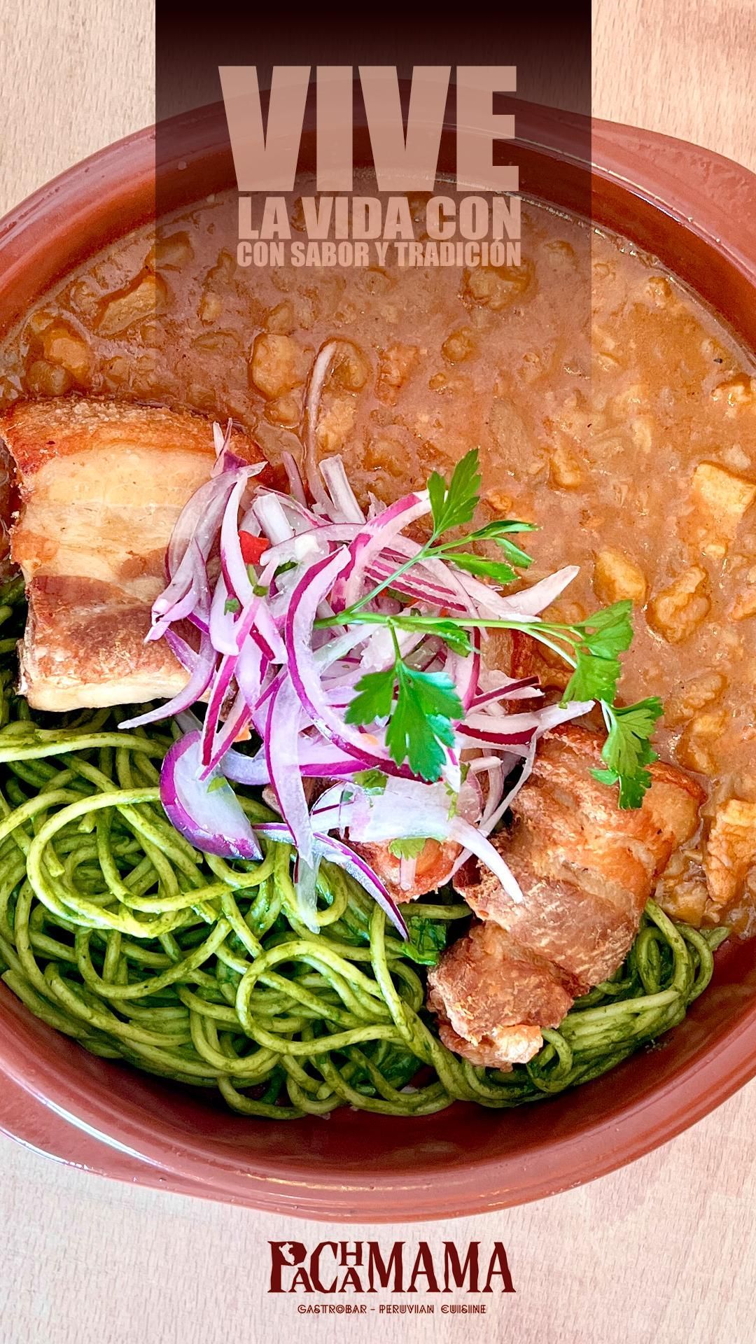 Un plato de chuleta empanizada con pasta al pesto verde brillante cubierta con queso rallado, etiquetado como 