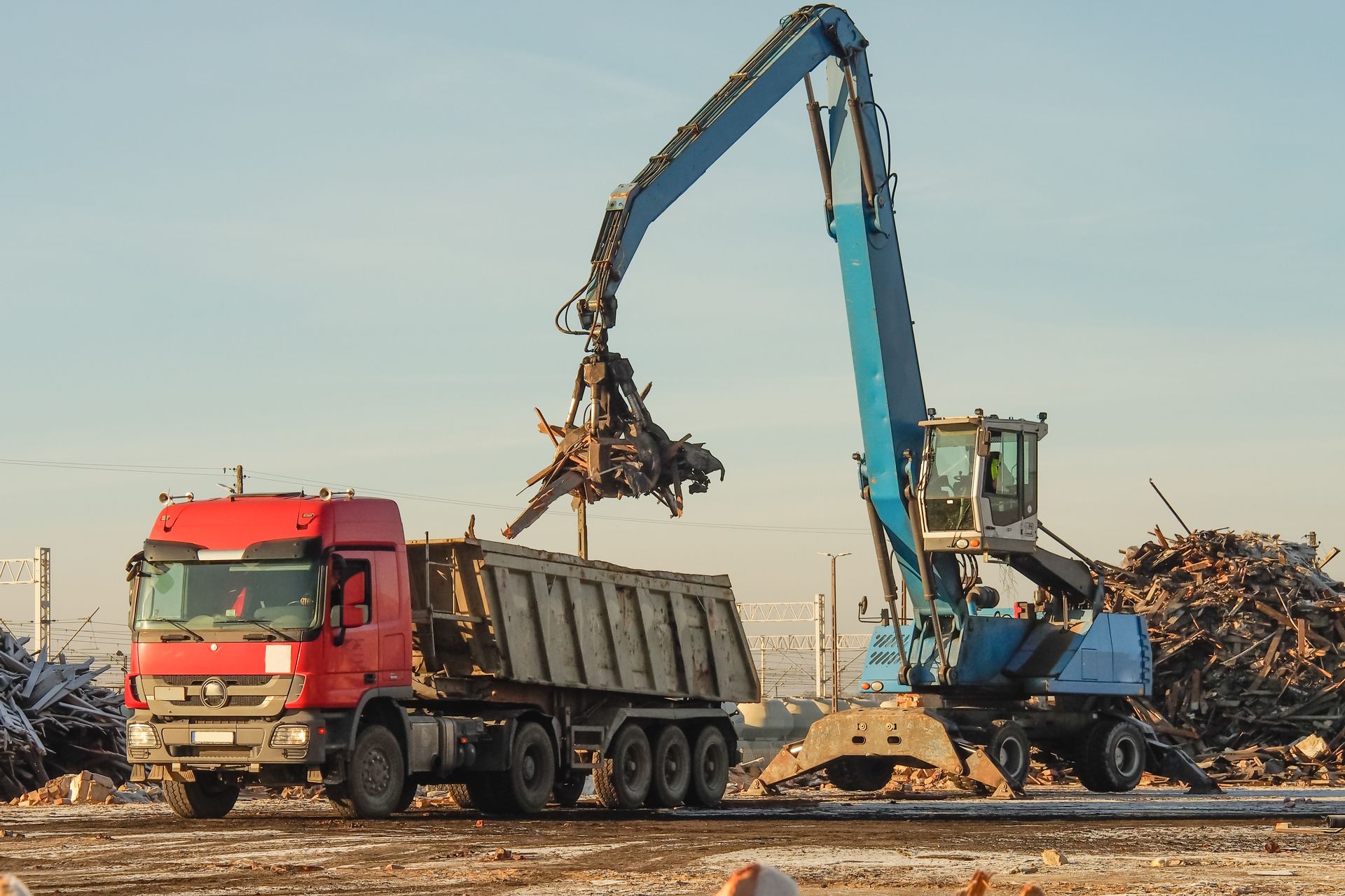 Une pelleteuse charge de la ferraille dans un camion-benne dans une casse.