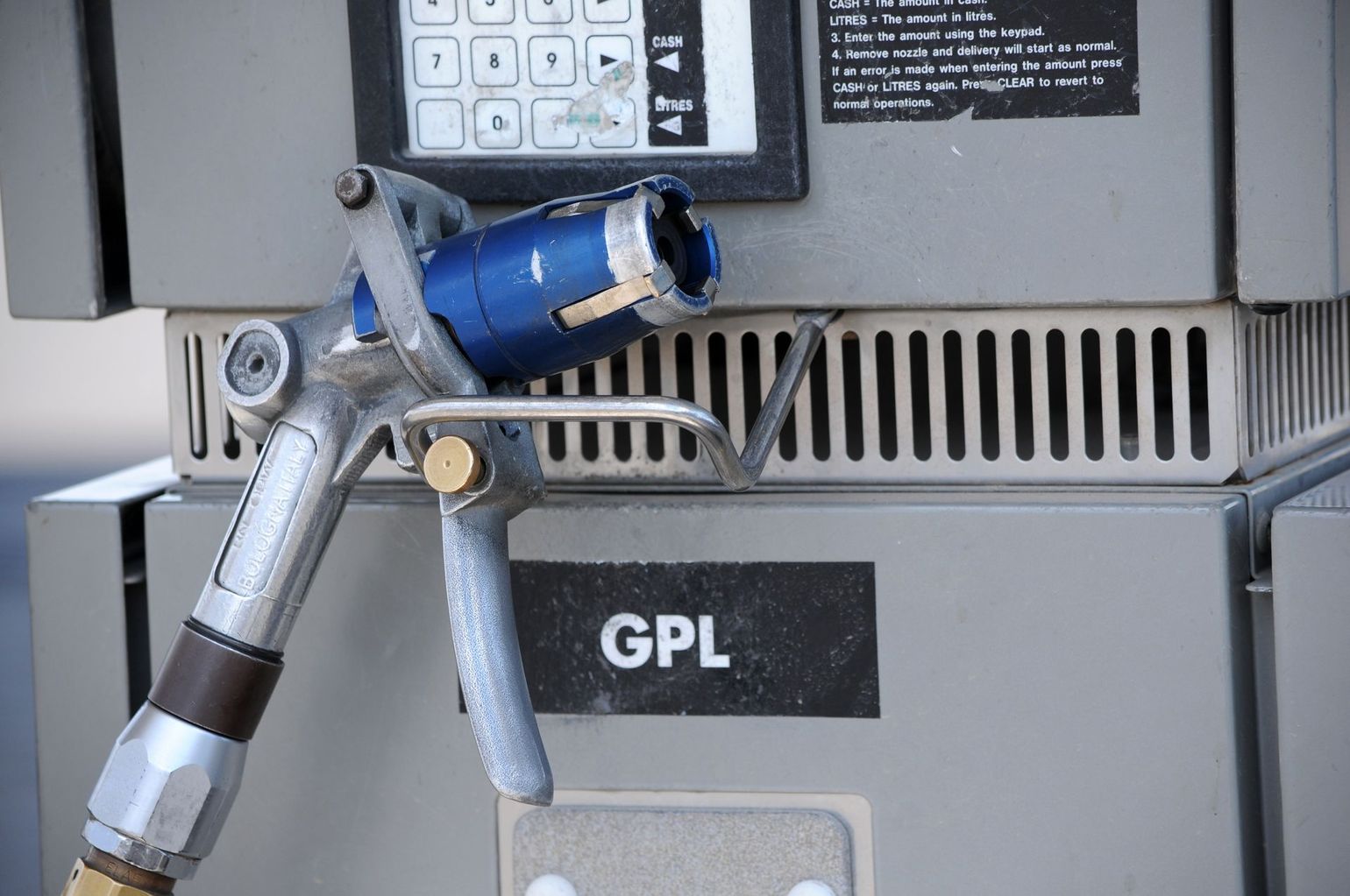 Pistolet de pompe à carburant pour GPL, embout bleu, sur une pompe grise, étiquette GPL.