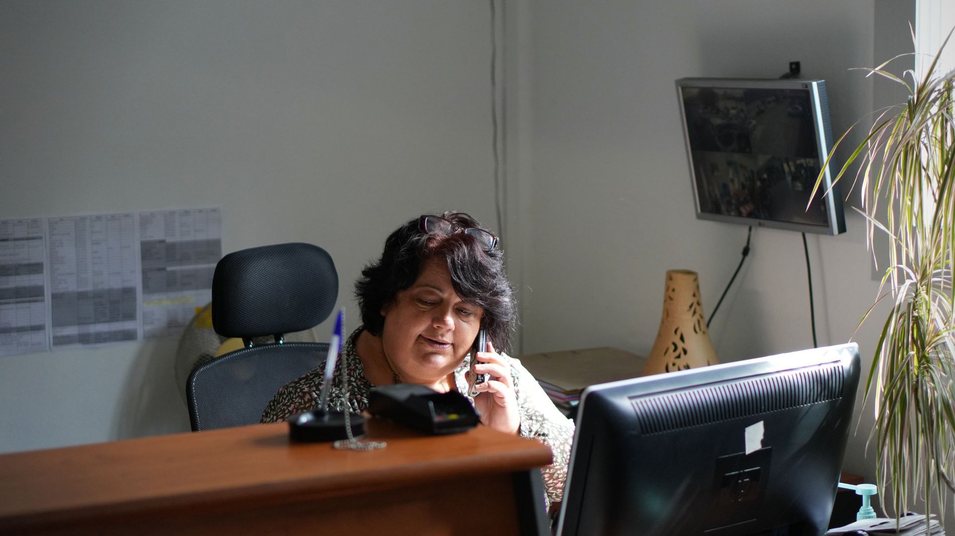 Mécanicien travaillant sur un moteur de voiture, portant des gants et utilisant un tournevis.