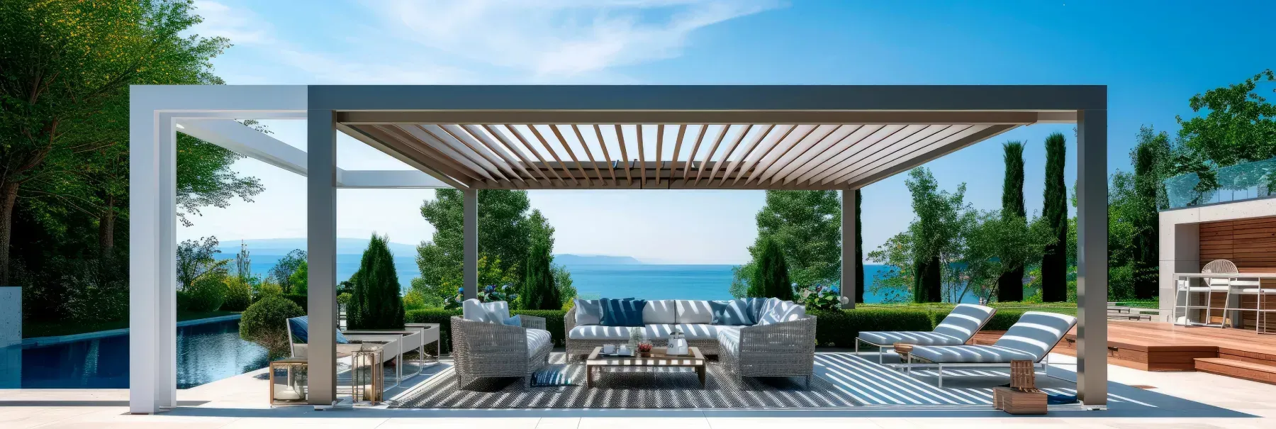 Espacio de estar al aire libre con pérgola, muebles de patio y vista al mar.