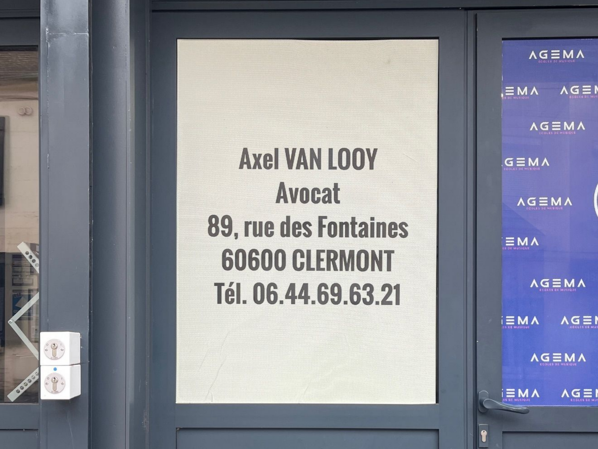 Panneau sur une porte : Axel Van Looy, avocat, adresse et numéro de téléphone.