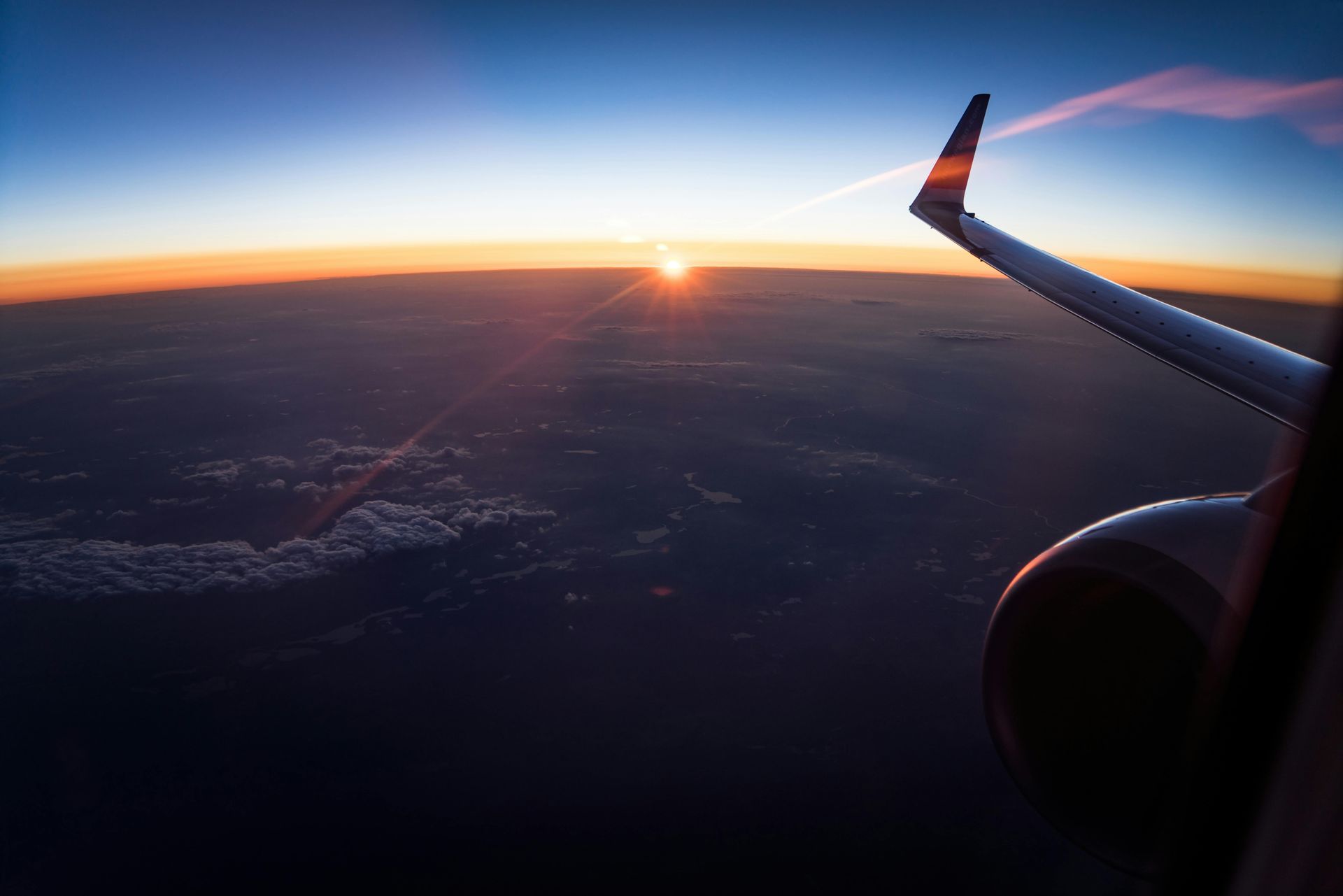 El sol se pone detrás del ala de un avión