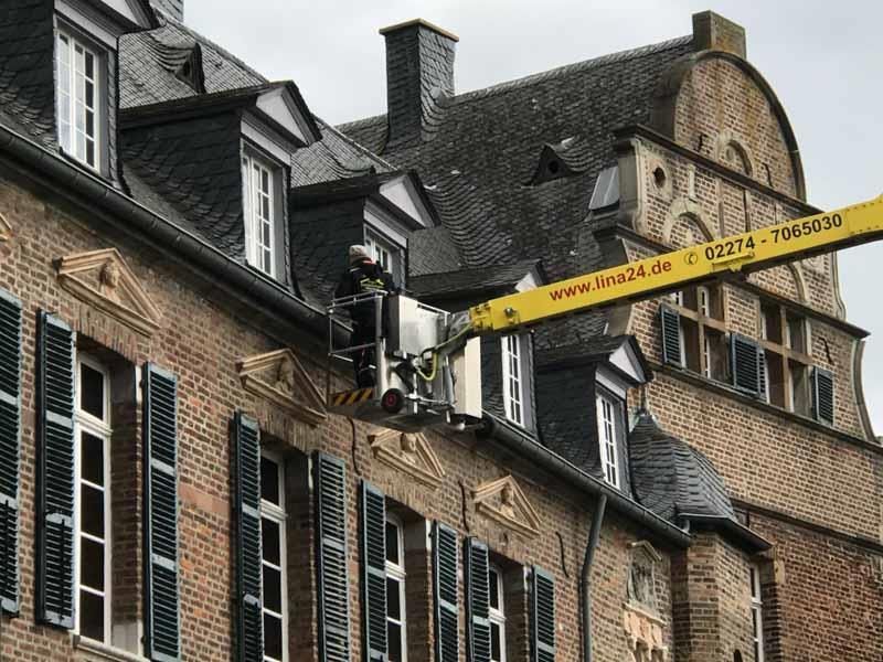 Ein Mann arbeitet auf dem Dach eines Backsteingebäudes