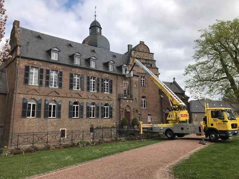 Ein gelber Lastwagen steht vor einem großen Backsteingebäude.