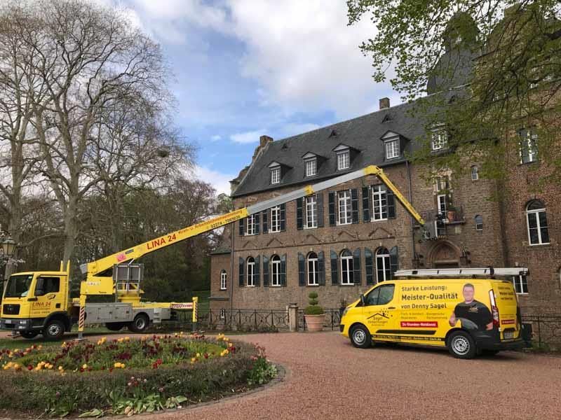 Ein gelber Lieferwagen parkt vor einem großen Gebäude.
