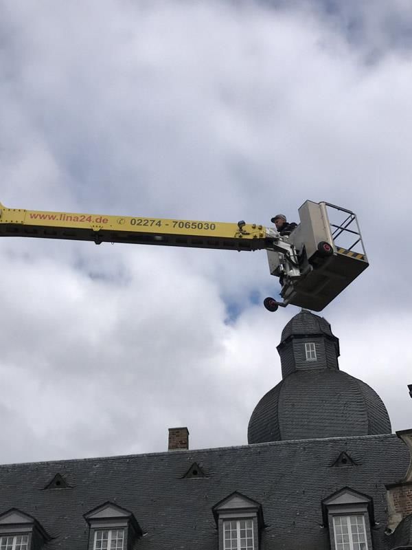 Ein gelber Kran sitzt auf einem Gebäude