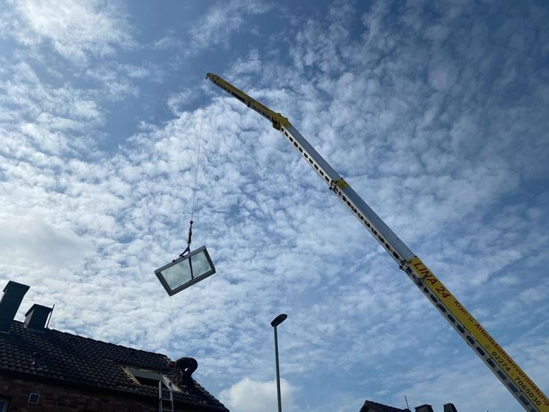 Ein Kran hebt ein Fenster in die Luft