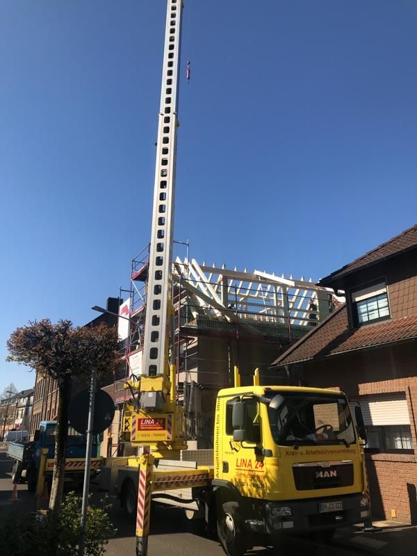 Ein gelber LKW mit einem daran befestigten Kran