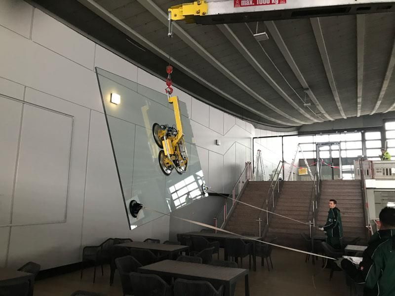 Ein großes Stück Glas wird von einem Kran angehoben