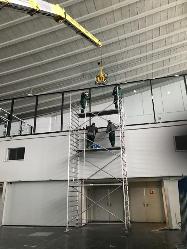 Eine Gruppe von Menschen steht auf einem Gerüst in einem Gebäude.